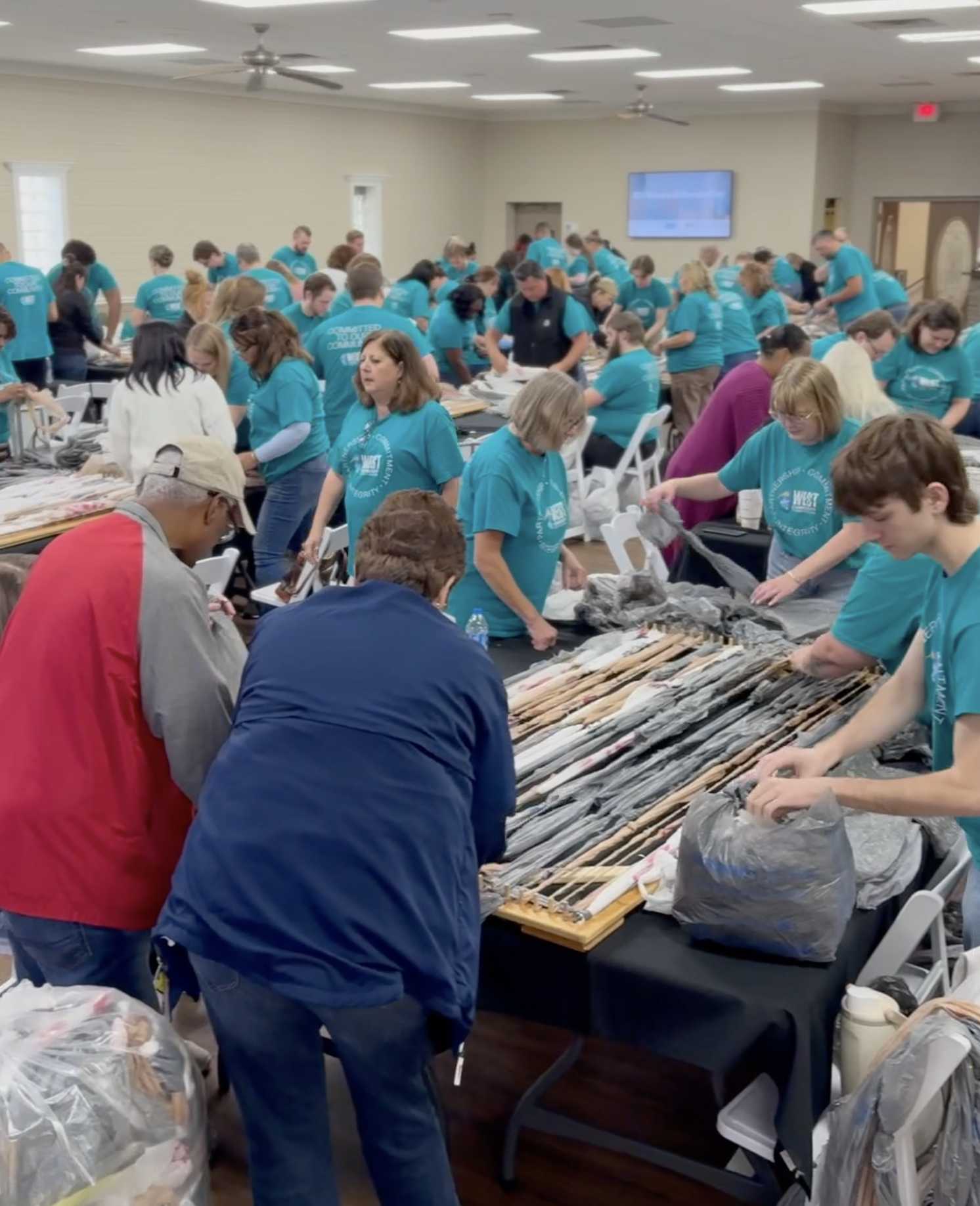 Photo of the staff weaving sleep mats from plastic bag donations on CU Make a Difference Day.